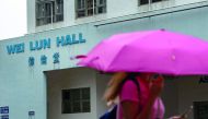 A student walks in front of University of Hong Kong's Wei Lun Hall, the residential block where university professor Cheung Kie-chung and his family lived, in Ho1ng Kong's Pok Fu Lam area on August 29, 2018.  AFP / Philip Fong 