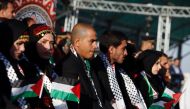 FILE PHOTO: Palestinian couples sit on stage during a group wedding celebration held on November 24, 2016 for 27 couples organised by Fatah movement. AFP / Jaafar Ashtiyeh