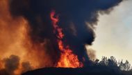 (FILES) In this file photo taken on August 3, 2018 flames estimated by firefighters to be 60-80 metres in height (200-260 feet), engulf a ridge as the River fire again threatens the town of Lakeport, California.  AFP / Mark Ralston 