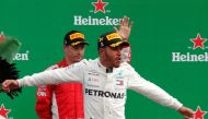 Mercedes' Lewis Hamilton celebrates on the podium after winning the race as Ferrari's Kimi Raikkonen waves to the crowd REUTERS/Stefano Rellandini

