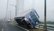 A truck sitting at an angle after being blown over by strong winds caused by Typhoon Jebi on the Seto Ohashi bridge in Sakade, Kagawa prefecture on Japan's Shikoku island.   AFP PHOTO 
