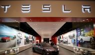 In this file photo taken on February 19, 2014, people look at a Tesla Motors vehicle on the showroom floor at the Dadeland Mall in Miami, Florida.  AFP / Getty Images North America / Joe Raedle 
