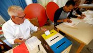 An election official drops a ballot in the ballot box at the polling station during a general election in Stockholm, Sweden September 9, 2018. REUTERS/Ints Kalnins