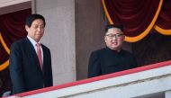 North Korea's leader Kim Jong Un (C) walks with China's Chairman of the Standing Committee of the National People's Congress Li Zhanshu (L) on a balcony of the Grand People's House on Kim Il Sung square following a military parade and mass rally in Pyongy