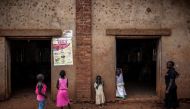(FILES) In this file photo taken on August 19, 2018 young Congolese girls look at a poster explaining the symptoms of Ebola in Mangina, near Beni, in the North Kivu province. AFP / John WESSELS