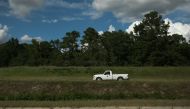 A county worker drives astride the levy along Lowery Street September 10, 2018 in Lumberton, North Carolina, ahead of Hurricane Florence. AFP / Logan Cyrus