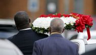 A person carrying a wreath of flowers walks through the parking lot at the Greenville Avenue Church of Christ for the funeral service for Botham Shem Jean on September 13, 2018 in Richardson, Texas. Stewart F. House/Getty Images/AFP 