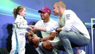 Mercedes' British driver Lewis Hamilton (C) and Mercedes' Finnish driver Valtteri Bottas speak with three-year-old fan Leila during a 'meet and greet' event at a shopping mall ahead of the Singapore Formula One Grand Prix in Singapore on September 13, 201