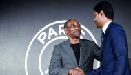 The Jordan Brand's president Larry Miller (L) shakes hands with Paris Saint-Germain's Qatari president Nasser Al-Khelaifi at the Parc des Princes stadium in Paris on September 13, 2018 during the presentation of PSG's UEFA Champions League new jerseys mad
