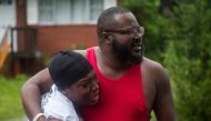 A father and daughter learn that friends were injured in a house that a tree fell on during landfall of Hurricane Florence, in Wilmington, North Carolina on September 14, 2018.  AFP / Andrew Caballero-Reynolds 