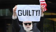 A protester holds a sign outside the US Courthouse in Alexandria, Virginia, on the fourth day in fraud case against former Trump campaign manager Paul Manafort on August 21, 2018. AFP / Jim Watson 