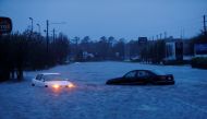 An abandoned car's hazard lights continue to flash as it sits submerged in a rising flood waters during pre-dawn hours after Hurricane Florence struck in Wilmington, North Carolina, U.S., September 15, 2018. REUTERS/Jonathan Drake
