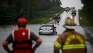 A car is stalled in flowing water, as first responders and firefighters try to check for people inside, during the pass of Hurricane Florence in the town of Clinton, North Carolina, U.S., September 15, 2018. REUTERS/Eduardo Munoz