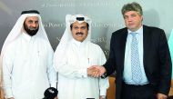 Khalid Mohammed Jolo (centre), CEO of Nebras; and Michel Peek (right), CEO of Zon Exploitatie Nederland Holding, shake hands as Faisal Al Siddiqi, Business Development Director of Nebras, looks on.