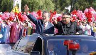 North Korean leader Kim Jong Un (R) and South Korean President Moon Jae-in (L) wave to Pyongyang citizens from an open-topped as they drive through Pyongyang on September 18, 2018. AFP PHOTO / Pyeongyang Press Corps