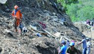 A rescuer guides his sniffer dog while volunteers recuers search for landslide victims, triggered by heavy rains during Typhoon Mangkhut, in Itogon, Benguet province on September 18, 2018. AFP / Ted Aljibe
