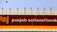 FILE PHOTO: A bird flies past the logo of Punjab National Bank installed on the facade of its office in Mumbai, India February 21, 2018. REUTERS/Danish Siddiqui/File Photo