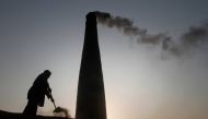 A man removes dirt from an oven to retrieve baked bricks at a brickyard in the outskirts of Islamabad December 28, 2011. Reuters/Faisal Mahmood 