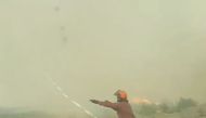 Firefighters try to pull a hose caught in a fire tornado in Vanderhoof British Columbia Canada in this still image taken from video August 19 2018. Instagram @MAR.LOWSKY/via Reuters 