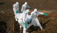 Health workers carry the body of a suspected Ebola victim for burial at a cemetery in Freetown, Sierra Leone, December 21, 2014. Reuters/Baz Ratner