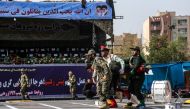 Iranian soldiers carrying away an injured comrade at the scene of an attack on a military parade that was marking the anniversary of the outbreak of its devastating 1980-1988 war with Saddam Hussein's Iraq. AFP / MORTEZA JABERIAN