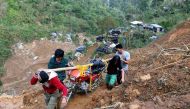 Residents carry a motorcycle as they hike on a road eroded by a landslide caused by Typhoon Mangkhut at a small-scale mining camp in Itogon, Benguet, in the Philippines, September 19, 2018. Reuters/Harlington Palangchao