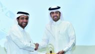 Qatar University President, Dr Hassan Al Derham, honours a QU member at the event. 