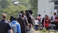 FILE PHOTO: A group of asylum seekers wait to be processed after being escorted from their tent encampment to the Canada Border Services in Lacolle, Quebec, Canada August 11, 2017. REUTERS/Christinne Muschi
