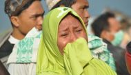 A woman cries as people look at the damages after an earthquake and a tsunami hit Palu, on Sulawesi island on September 29, 2018. AFP / MUHAMMAD RIFKI
