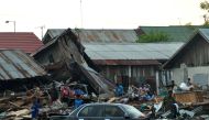 Residents trying to salvage belongings from their homes which collapsed after an earthquake and tsunami hit Palu on Sulawesi island on September 29, 2018.   AFP / MUHAMMAD RIFKI
