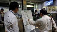 A passenger checks a message board announcing last train services ending earlier due to Typhoon Trami, at East Japan Railway Company's station in Tokyo, Japan, September 30, 2018. REUTERS/Issei Kato