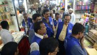 This photograph taken on September 27, 2018 shows city civic officers (in blue) during their visit to a wholesale market to inspect plastic bags usage in Mumbai. AFP / Punit PARANJPE 
