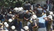 Pakistani policemen sit on armoured vehicle carrying opposition leader Shahbaz Sharif after the corruption court hearing in Lahore on October 6, 2018. (AFP / ARIF ALI)