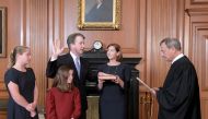 Judge Brett Kavanaugh is sworn in as an Associate Justice of the U.S. Supreme Court by Chief Justice John Roberts as Kavanaugh's wife Ashley holds the family bible and his daughters Liza and Margaret look on in a handout photo provided by the U.S. Supreme