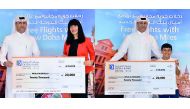 A Doha Bank official with two of the lucky winners.