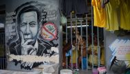 This photo taken on August 13, 2018, inmates standing next to a portrait of Philippine President Rodrigo Duterte inside the city jail in Manila. AFP / TED ALJIBE 