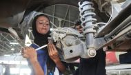 In this picture taken on September 1, 2018, Pakistani motor mechanic Uzma Nawaz, 24, fixes a car at an auto workshop in Multan.  / AFP / S.S. Mirza 