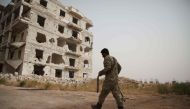 A Syrian rebel-fighter from the National Liberation Front (NLF) walks in a street in the rebel-held al-Rashidin district of western Aleppo's countryside near Idlib province, on October 15, 2018.   AFP / Aaref WATAD