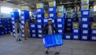 Afghan employees of the Independent Election Commission (IEC) carry ballot boxes at a warehouse in Herat province on October 17, 2018.  AFP / HOSHANG HASHIMI
