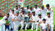 Pakistan's cricket team celebrates at the end of day four of the second Test match between Australia and Pakistan at Sheikh Zayed stadium in Abu Dhabi on October 19, 2018.  AFP / Karim Sahib
