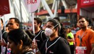 An Indian runner wears a face mask as she participates in the New Delhi half marathon in the Indian capital on October 21, 2018.  / AFP / CHANDAN KHANNA 