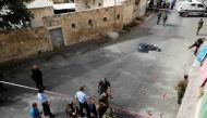 The dead body of a Palestinian is covered as Israeli forces gather at the scene of a stabbing attack in Hebron, in the occupied West Bank October 22, 2018. REUTERS/Mussa Qawasma