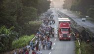 Honduran migrants taking part in a caravan heading to the US, walk alongside the road in Huixtla, Chiapas state, Mexico, on October 24, 2018.   AFP / PEDRO PARDO