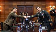 This handout photo taken on October 26, 2018 and provided by the South Korean Defence Ministry shows South Korea's chief delegate Major General Kim Do-gyun (R) shaking hands with his North Korean counterpart An Ik San (L) during their general-level milita