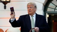 US President Donald Trump holds up a Halloween candy with his signature on it before giving it to trick-or-treaters at the White House in Washington, U.S., October 28, 2018. REUTERS/Joshua Roberts
 