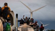 A truck carrying mostly Honduran migrants taking part in a caravan heading to the US, passes by a wind farm on their way from Santiago Niltepec to Juchitan, near the town of La Blanca in Oaxaca State, Mexico, on October 30, 2018. AFP / GUILLERMO ARIAS
