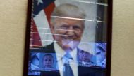 :FILE PHOTO: Televised pictures of parcel bombs suspect Cesar Sayoc are reflected in the official portrait of U.S. President Donald Trump at the Justice Department in Washington, U.S. October 26, 2018. REUTERS/Jonathan Ernst