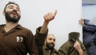 French national Romain Franck (covering his face),  a worker at the French consulate, and Palestinian Moufak al-Ajluni and Mohamed Katout appear in court the southern Israeli city of Beer Sheva on March 19, 2018. AFP/Jack Guez