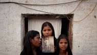 The daughters of Pakistani Christian woman Asia Bibi pose with an image of their mother while standing outside their residence in Sheikhupura located in Pakistan's Punjab Province November 13, 2010.  Reuters/Adrees Latif