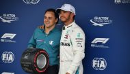 Mercedes' British driver Lewis Hamilton receives the pole position award from the Brazilian former driver Felipe Massa after taking the pole position for the F1 Brazil Grand Prix in the qualifying session at the Interlagos racetrack in Sao Paulo, Brazil o